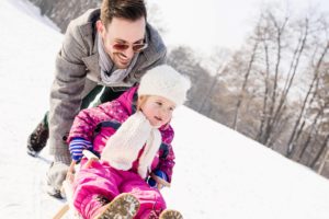 Bild von Vater und Tochter beim Rodeln