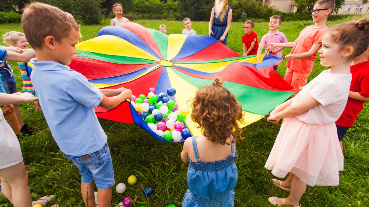 Kinder bilden einen Spielkreis mit einem Tuch